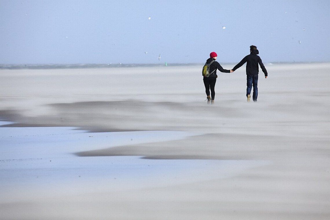 Spaziergänger am Strand in Friesland