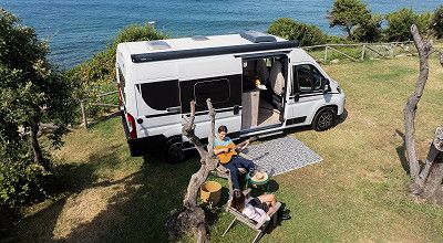 Laika Campervan Ecovip auf einer Wiese mit Meer im Hintergrund