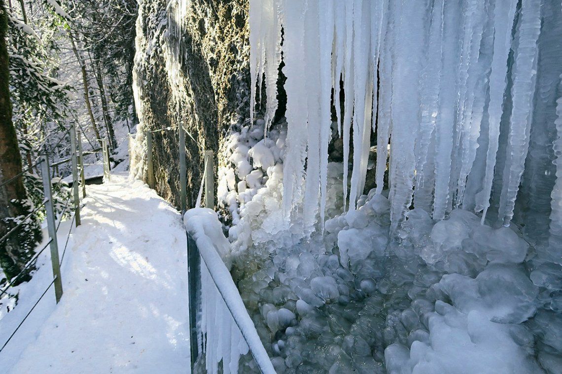 Verschneiter Weg und Eiszapfen am Eistobel im Winter