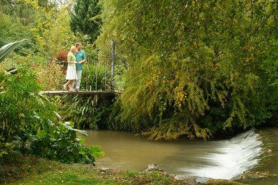 Haengebruecke aus Holz ueber dem Fluss Varty in Mount Usher Gardens