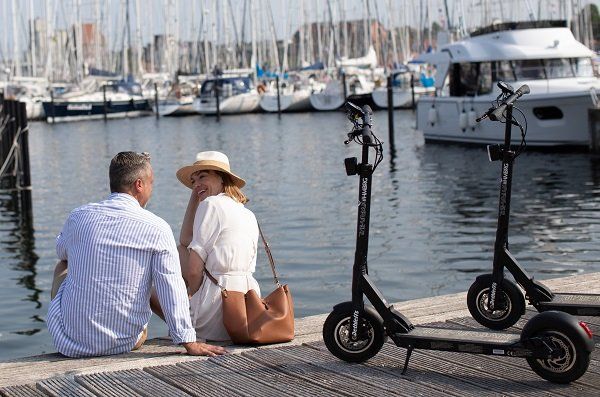 Paar mit Dethleffs E-Scooter im Hafen