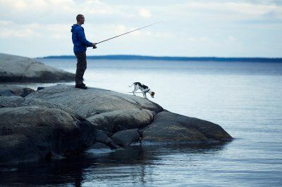 Angler mit Hund auf einer Schäreninsel in Schweden
