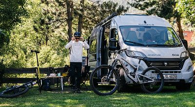 Sunlight Campervan Cliff Adventure 602 auf Stellplatz im Grünen mit Fahrrädern davor