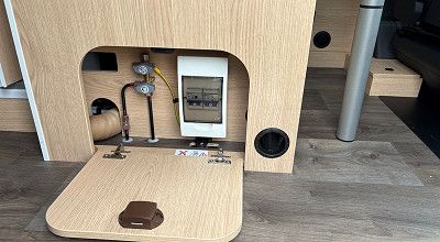 Gasabsperrhahn und Stromsicherungen an der Seite der Dinettenbank im Sunlight Campervan Cliff 4x4 Greentrek