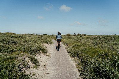 Fahrradfahrerin in den Dünen auf Borkum
