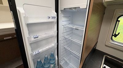 Offener Kuehlschrank mit Wasserflaschen im Corigon Wohnmobil T 70 S