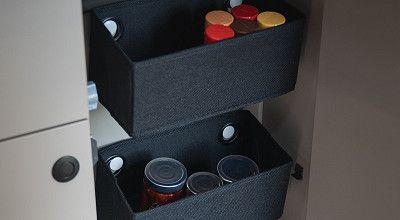 Stoffboxen mit Gewuerzen und Vorraeten im Kuechenschrank eines LMC Tracer Wohnmobils