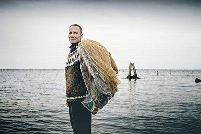Fischer mit Fischernetz auf Nyord am Meer