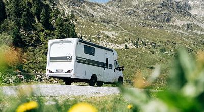 Corigon Wohnmobil der Baureihe Teilintegriert Advanced von hinten gesehen in den Bergen 