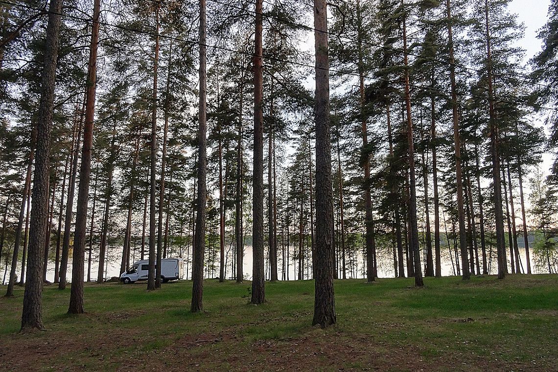 A motorhome by a lake in a forest in Finland