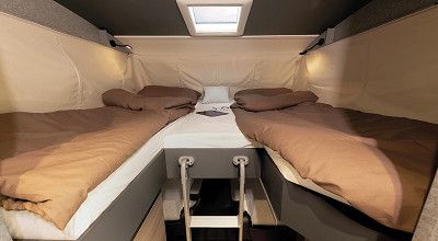 Hubbett mit Einzellängsbetten über dem Fahrerhaus des Dethleffs Trend I 7027