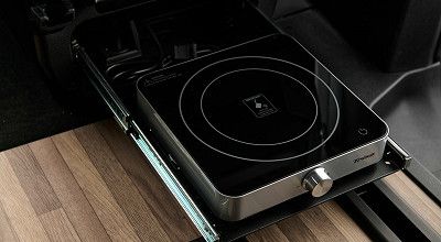 Induktionskochplatte auf Auszugsschiene unter dem Beifahrersitz im Crosscamp Campingbus EXPLR 5.0