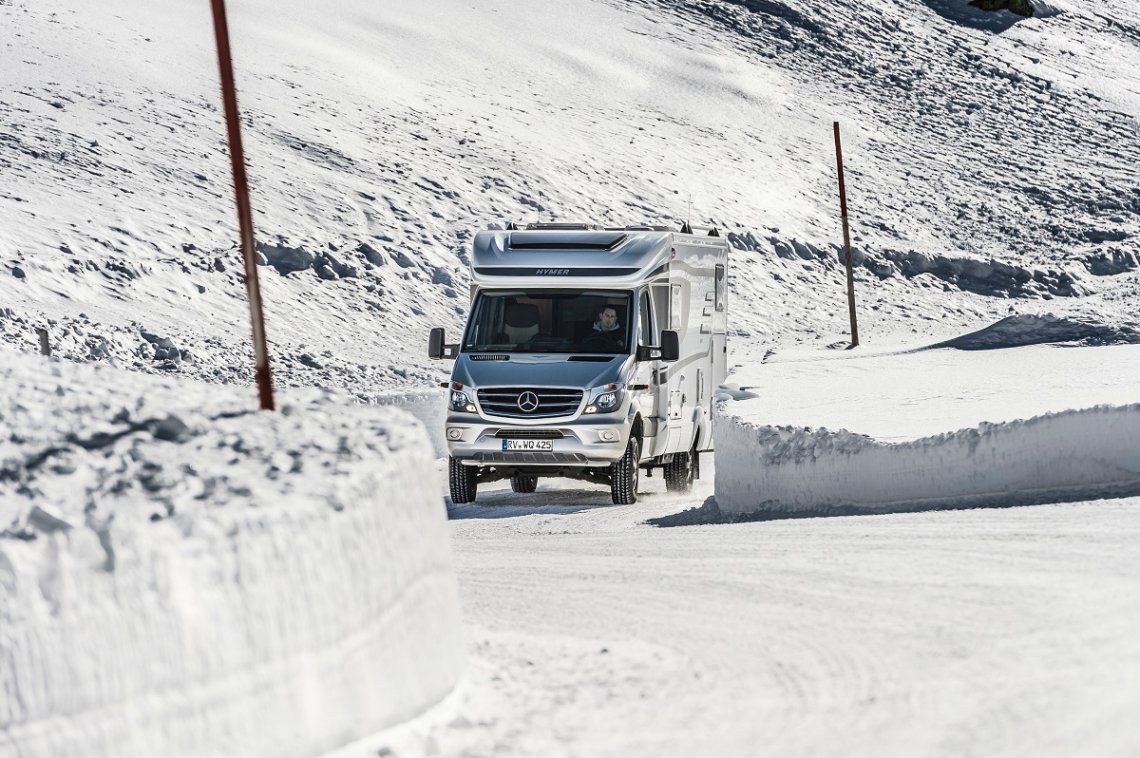 Hymer Reisemobil auf verschneiter Strasse in den Bergen