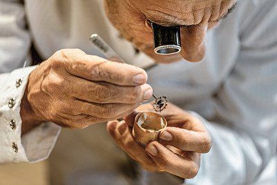 A watchmaker with a magnifying glass and clockwork mechanism
