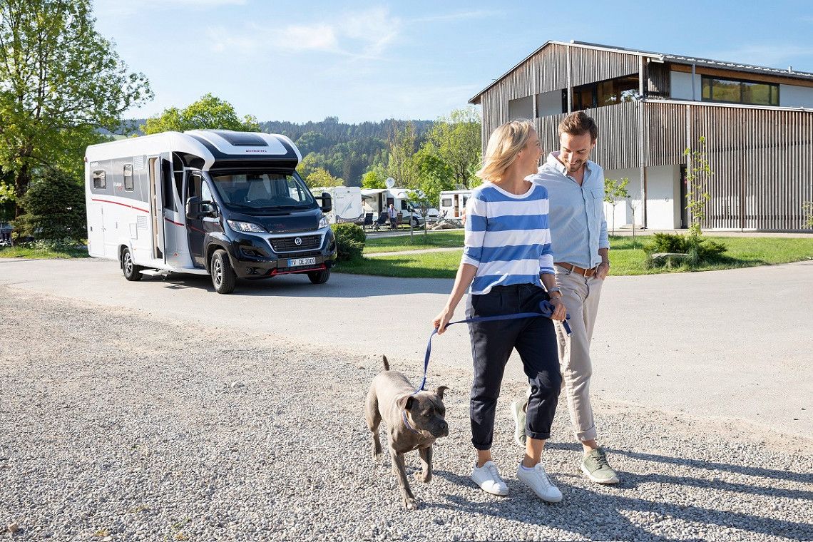 Dethleffs Wohnmobil mit Hund und Besitzern auf dem Campingplatz