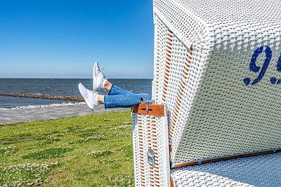 Beine baumeln aus Strandkorb in Buesum an der Nordsee