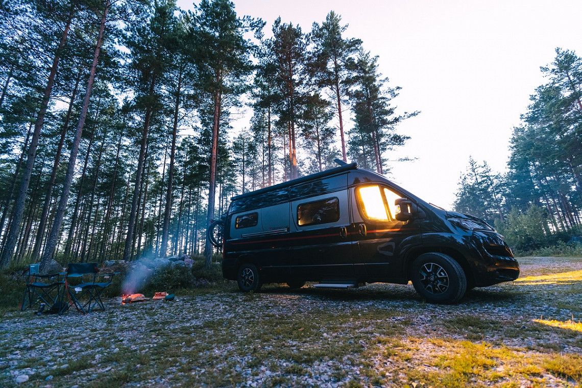 Dethleffs Campervan Globetrail auf Parkplatz in Norwegen am Wald