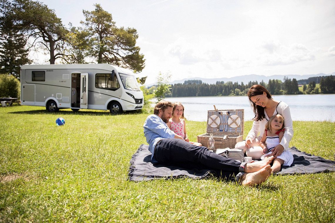 Family picnic by the lake with a Dethleff's motorhome