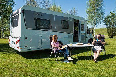 Camper mit Tisch und Stühlen vor dem Dethleffs Wohnmobil