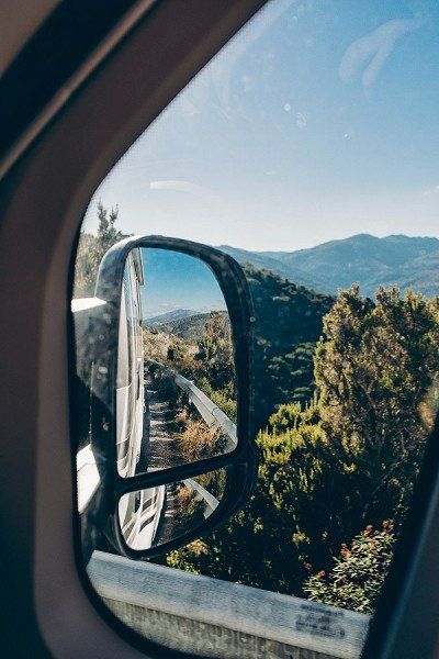 Zicht op Sardinië vanuit de achteruitkijkspiegel van de camper