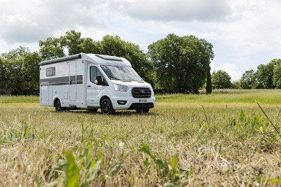Corigon Wohnmobil der Baureihe Teilintegriert Slim von aussen auf einer Wiese
