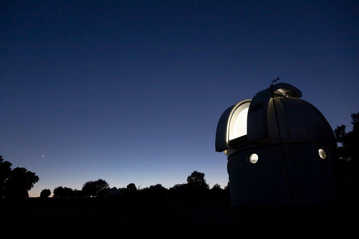 Nachtelijke hemel boven het verlichte observatorium Saint-Michel