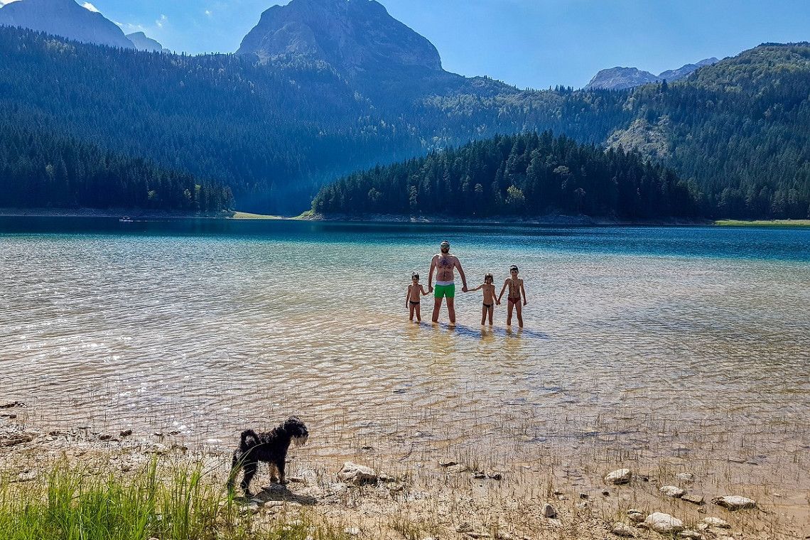 A father with children and a dog in a lake in Montenegro