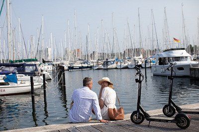 Paar mit E-Scooter im Hafen