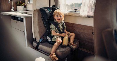 Child sitting in a child seat in the back of a Carado motorhome - have a look at the Carado motorhomes now