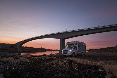 Hymer Wohnmobil ML-T bei Sonnenuntergang unter Bruecke auf den Lofoten - mehr Infos zum ML-T gibt's hier bei Hymer