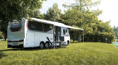 Dethleffs Wohnmobil XL Family I auf Wiese mit ausgefahrener Markise
