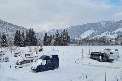 Blick auf den verschneiten Wohnmobilstellplatz Balderschwang