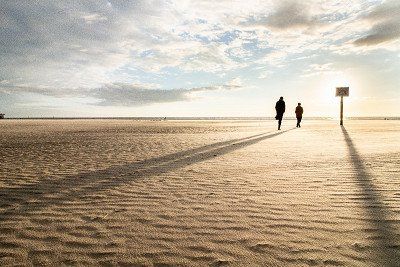 Personen am Nordseestrand beim Spaziergang 