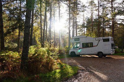 LMC Wohnmobil von McRent auf Parkplatz im Wald in Schottland 