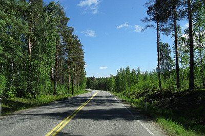 A road through a forest in the Saimaa Lake District