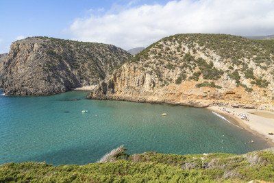 Zandstrand en rotsen in de baai van Cala Domestica