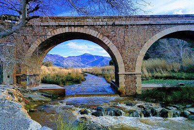 Steinbruecke ueber Fluss in Andalusien