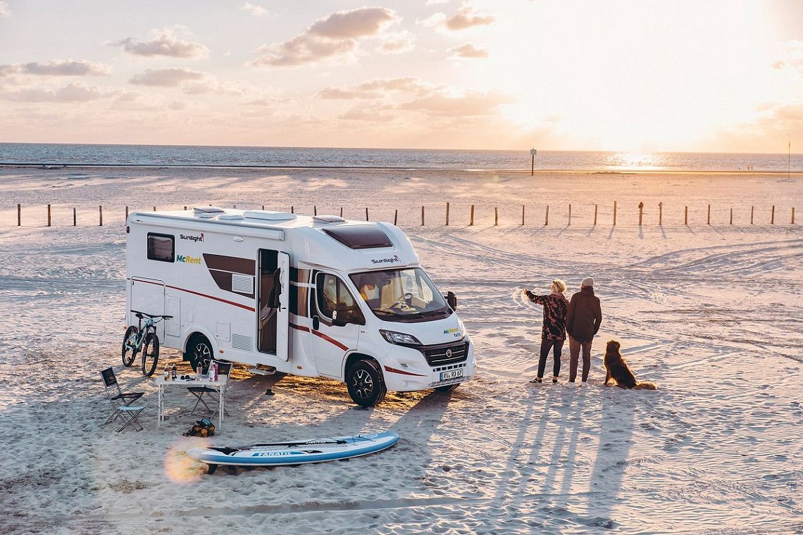 Sunlight rental camper on the beach at sunset