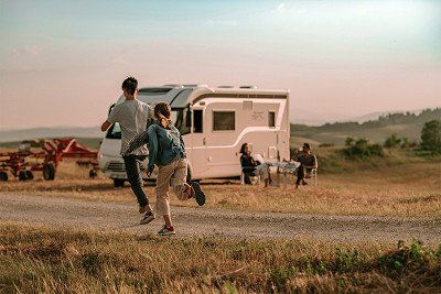 Kinder spielen vor Wohnmobilin italienischer Landschaft 